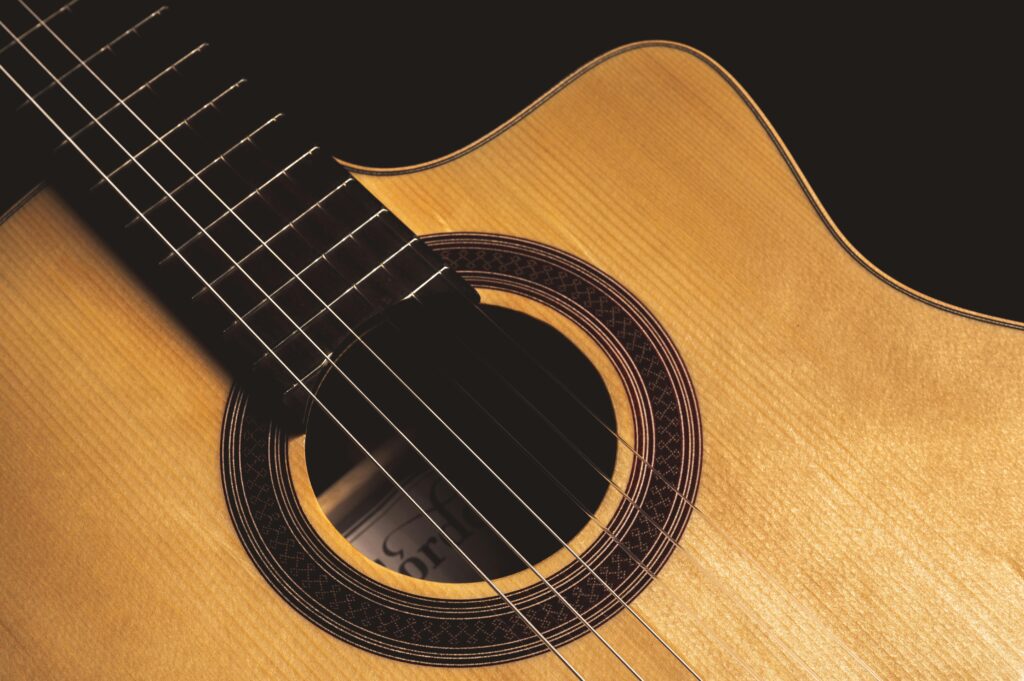 To the girl who believed in me, Detailed close-up of acoustic guitar body showing strings and rosette design.